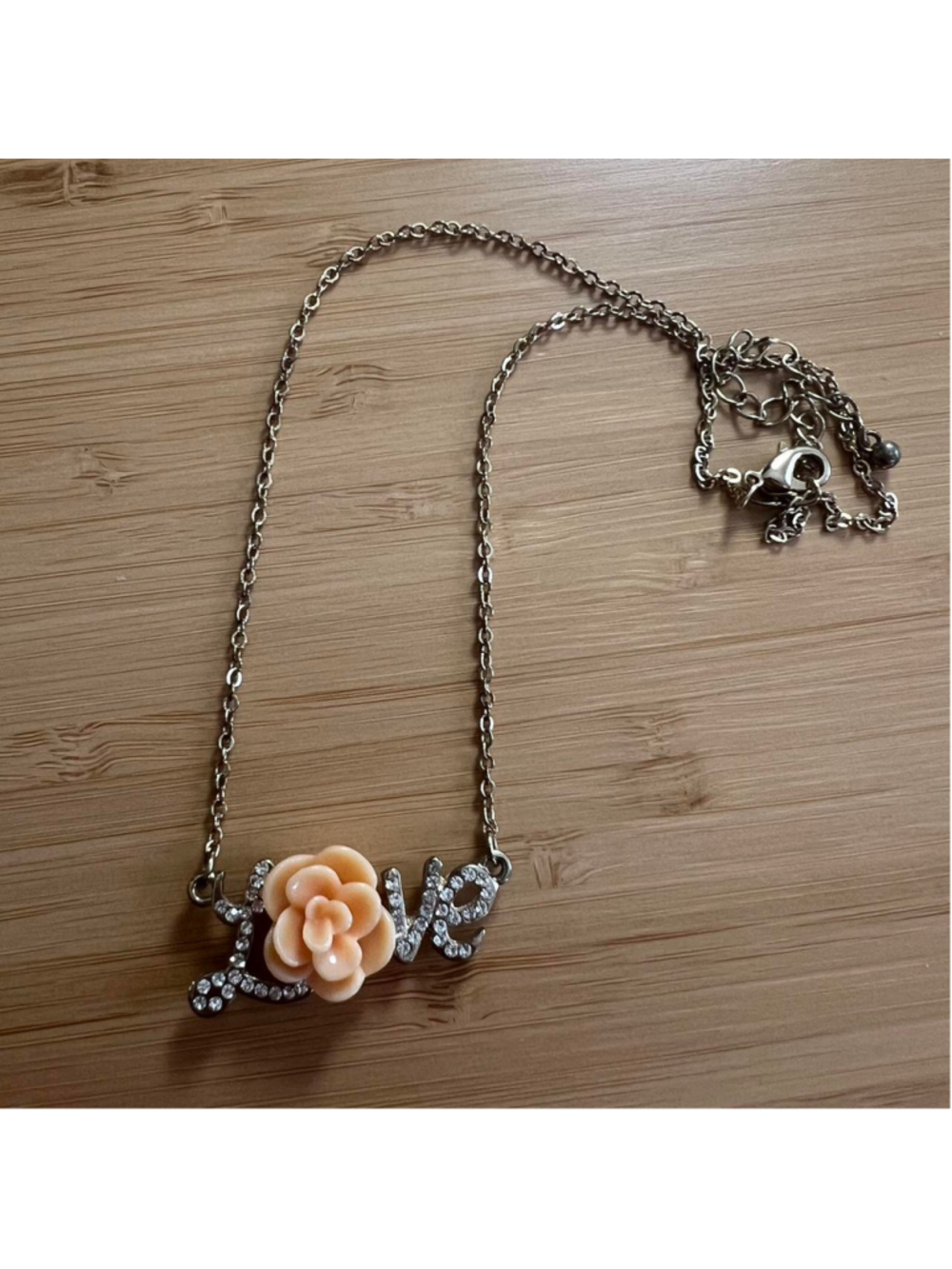 Gold ‘LOVE’ necklace with peach colored rose